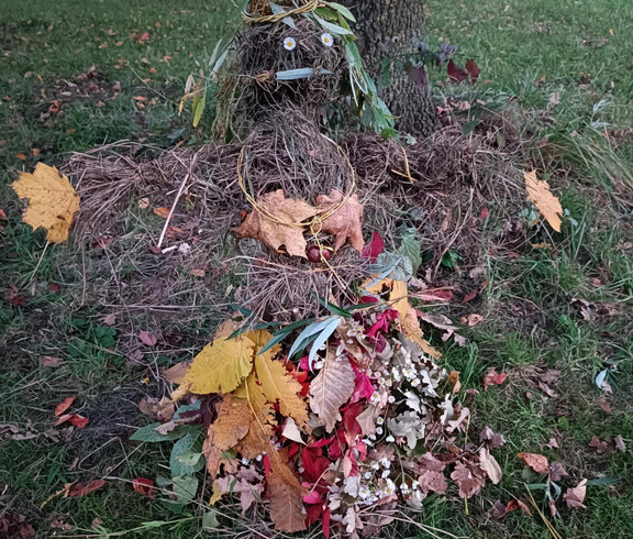 herbstliches Naturkunstwerk aus Blättern, Zweigen, Kiefernnadeln und Blüten.